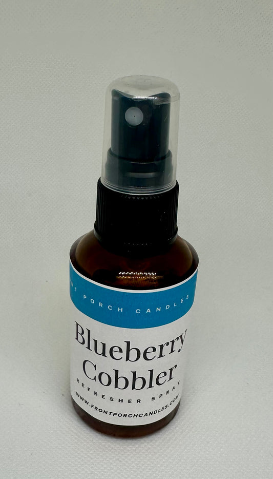 A brown spray bottle with a black nozzle, labeled "Blueberry Cobliner" and "Refresher Spray" on a white background.