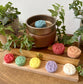 a wooden tray with four different colored bath bombs